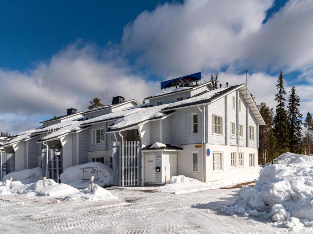 una casa blanca con nieve en el suelo en Holiday Home Yllästar 1 as 202 by Interhome, en Äkäslompolo