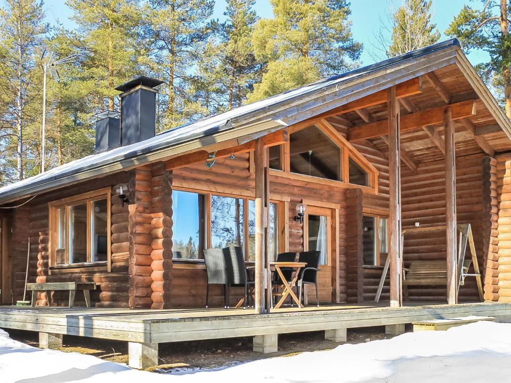 eine Blockhütte im Wald mit einer Veranda in der Unterkunft Holiday Home Mäntyniemi by Interhome in Konnevesi
