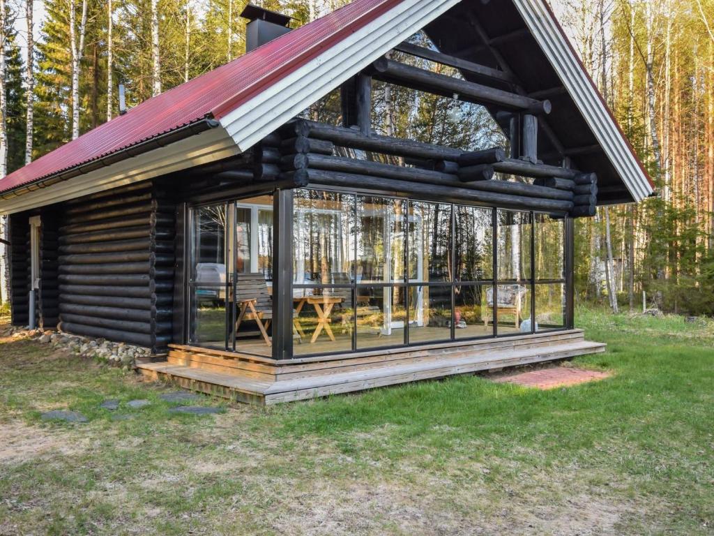 a log cabin with a porch and a roof at Holiday Home Leporanta by Interhome in Herttuala