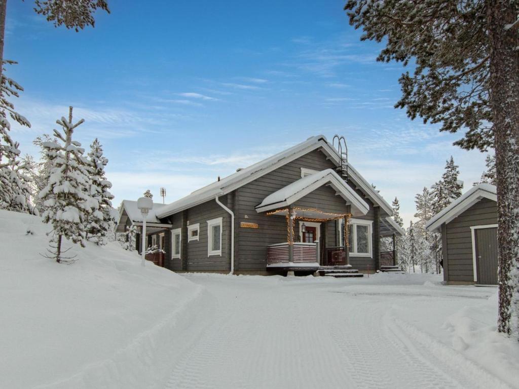 una casa en la nieve con una entrada cubierta de nieve en Holiday Home Päivänsäde 8 lapinkulta by Interhome, en Äkäslompolo