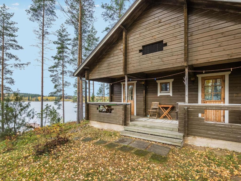 ein Holzhaus mit einer Veranda und einem Tisch in der Unterkunft Holiday Home Mäntykumpu by Interhome in Petäjävesi