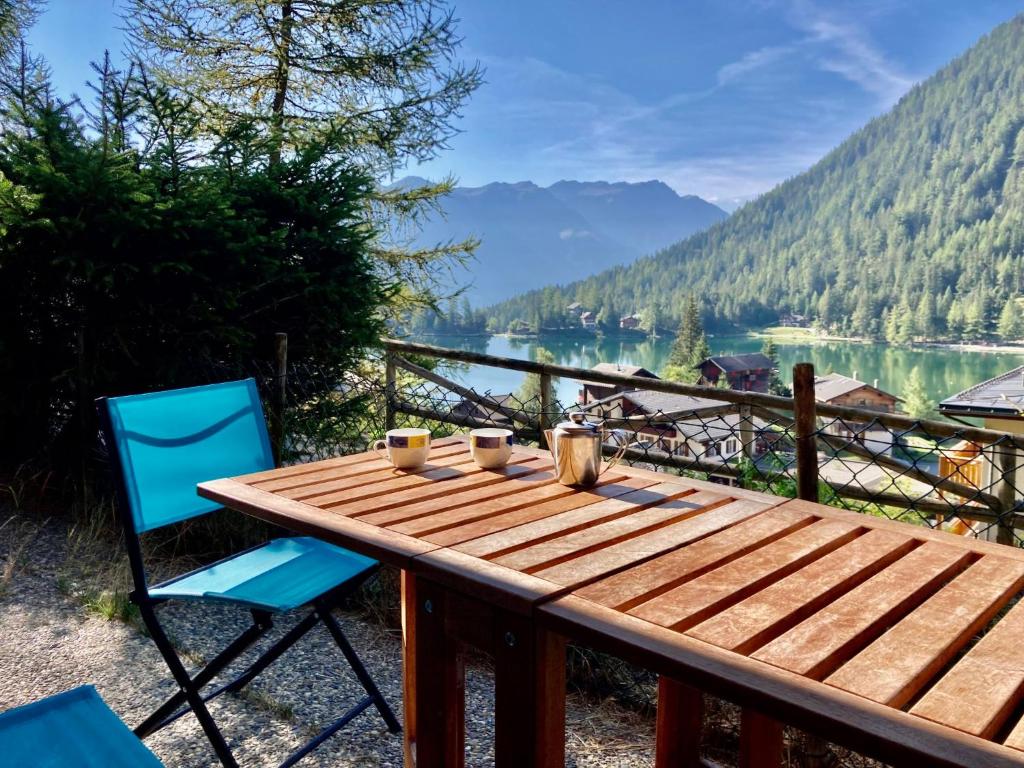 a wooden table and chairs with a view of a lake at Apartment Colline 3 by Interhome in Champex