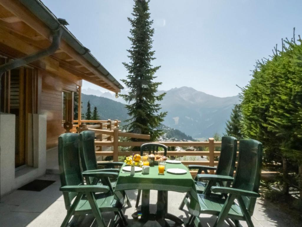 einen Tisch und Stühle auf einer Terrasse mit Bergen im Hintergrund in der Unterkunft Holiday Home Midat Soleil by Interhome in Verbier