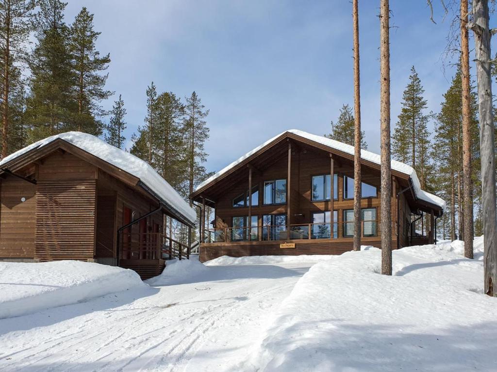 domek z bali na śniegu z drzewami pokrytymi śniegiem w obiekcie Holiday Home Äkäsmartti a by Interhome w mieście Äkäslompolo