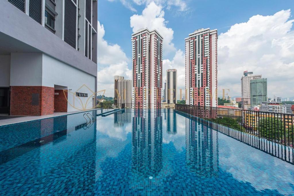 a swimming pool on the roof of a building with tall buildings at KLCC View with balcony Chambers Suites KL in Kuala Lumpur