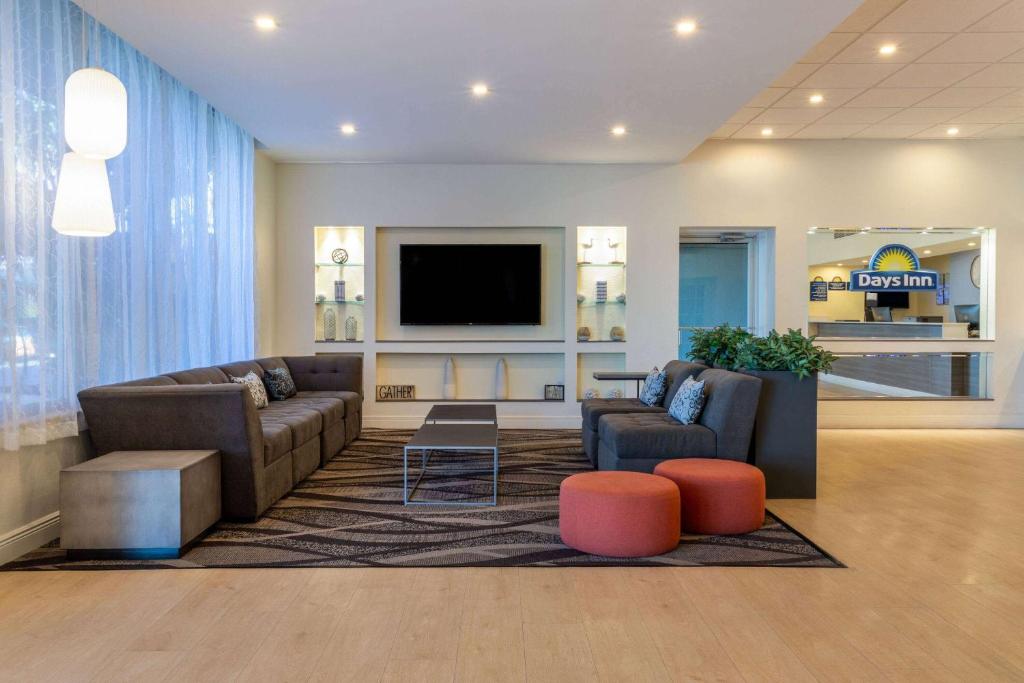 a living room with two couches and a flat screen tv at Days Inn by Wyndham Titusville Kennedy Space Center in Titusville