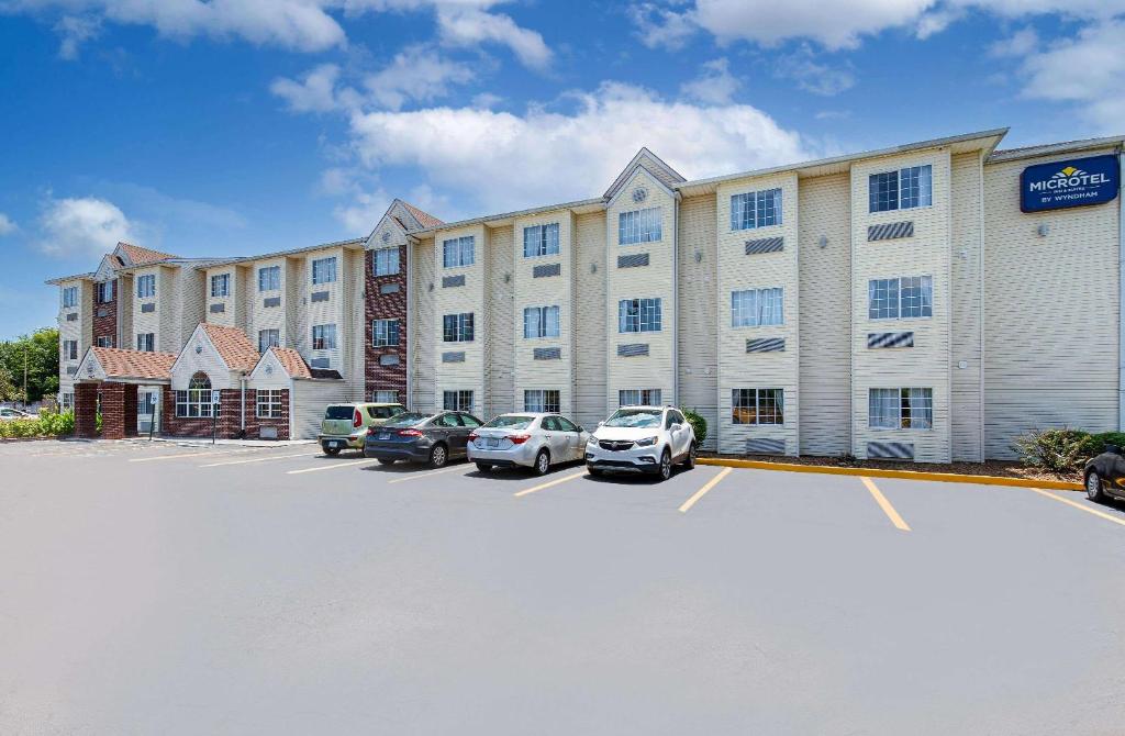 a large building with cars parked in a parking lot at Microtel Inn and Suites by Wyndham - Cordova in Memphis