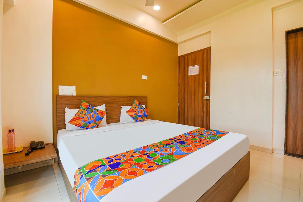 a bedroom with a large bed with a colorful blanket at FabHotel Royal Hospitality in Pune