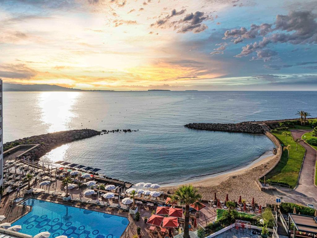 an aerial view of a resort with a pool and the ocean at Pullman Cannes Mandelieu Royal Casino in Mandelieu-la-Napoule