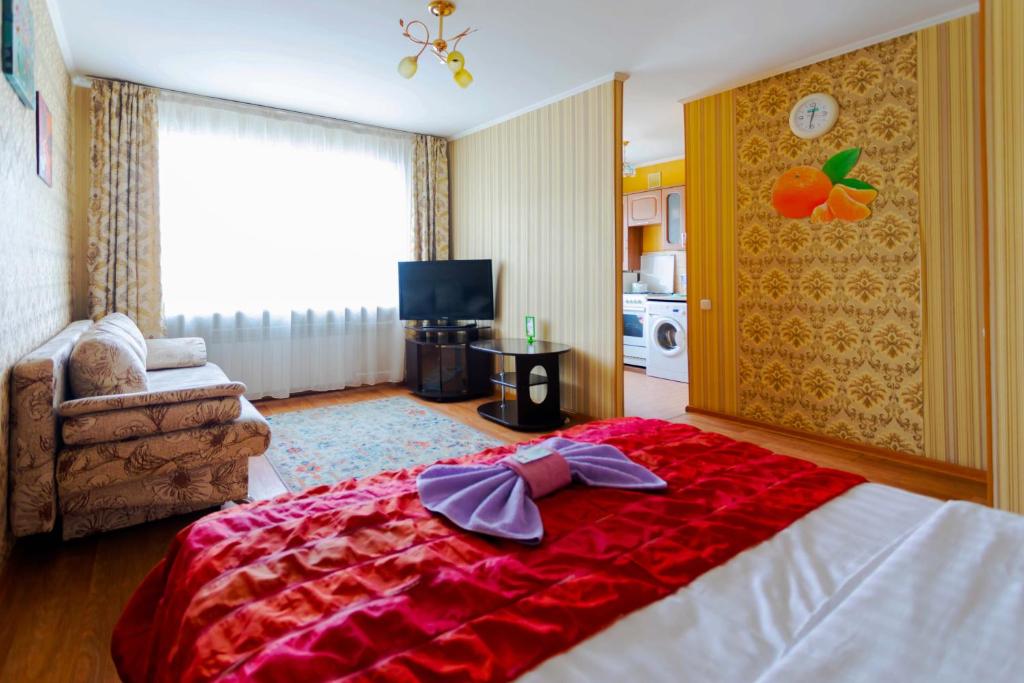 1 dormitorio con 1 cama grande con manta roja en Мандарин, en Petropavlovsk