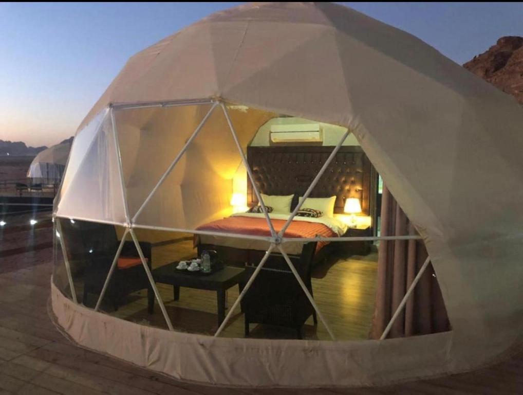 a small tent with a bed inside of it at Eileen luxury camp in Wadi Rum