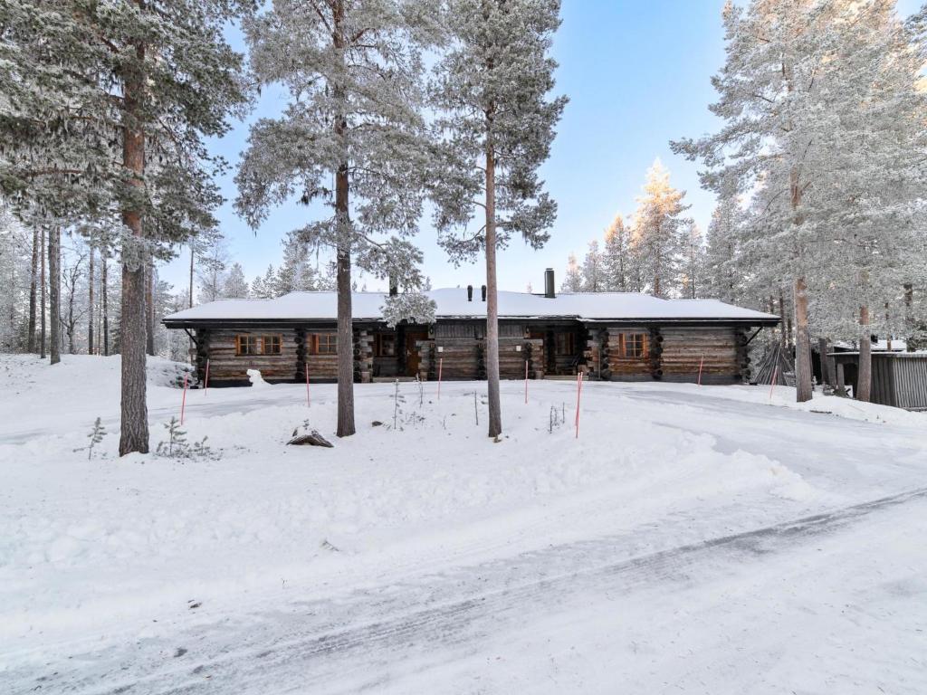 een blokhut in de sneeuw naast een weg bij Holiday Home Klasun maja a by Interhome in Ylläsjärvi