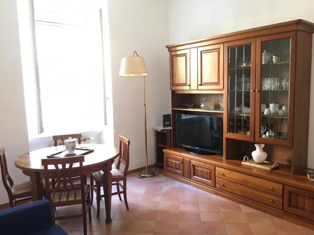 Una sala de estar con una mesa de comedor y un televisor. en Sweety Rome House, en Roma