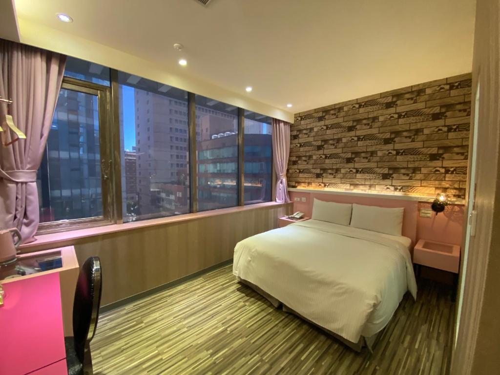 a hotel room with a bed and a large window at 191 Hotel in Taoyuan