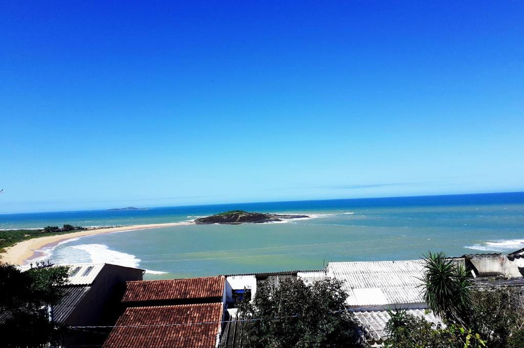 vistas a una playa con una isla en el agua en Casa na praia de Setiba com panorama fantástico, en Guarapari