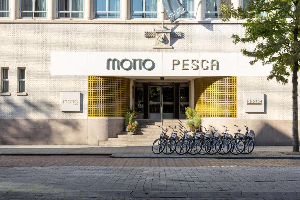 Motto By Hilton Rotterdam Blaak في روتردام: مجموعة من الدراجات متوقفة أمام متجر