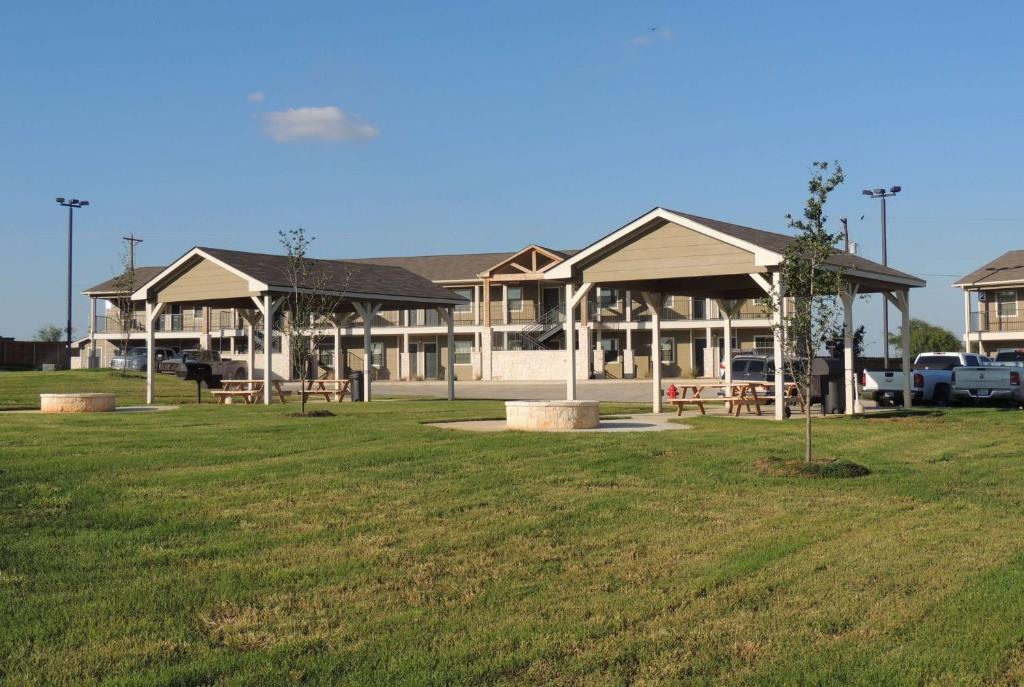 a large building with a park in front of it at Eagle's Den Suites Big Spring a Travelodge by Wyndham in Big Spring