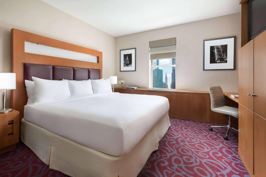 una camera con un grande letto bianco e una scrivania di Hotel 57 by LuxUrban a New York