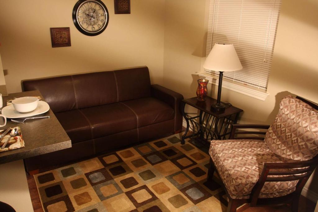 sala de estar con sofá y silla en Eagle's Den Suites Andrews a Travelodge by Wyndham, en Andrews