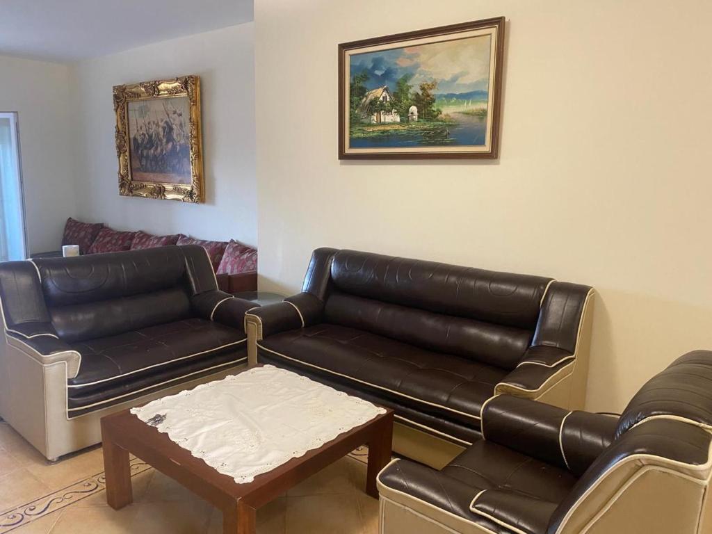 a living room with a leather couch and a table at Appartement à résidence Ap8 , marina , saidia in Berkawe