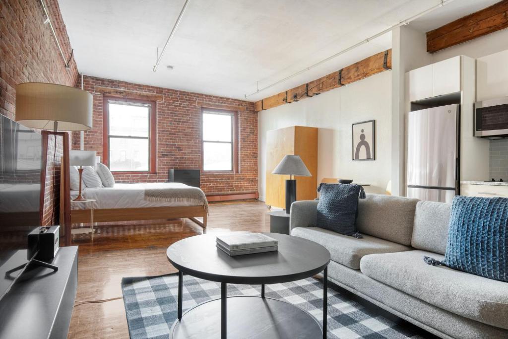 uma sala de estar com um sofá e uma mesa em South End studio w building wd nr dining BOS-903 em Boston
