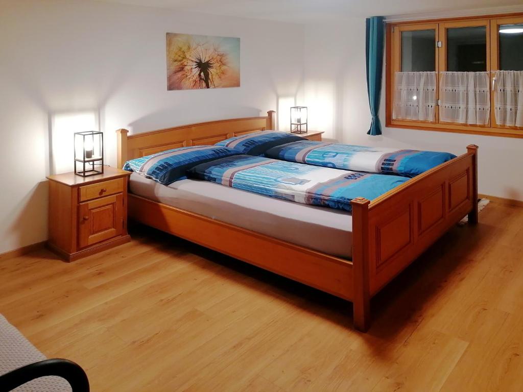 ein Schlafzimmer mit einem Bett mit einem Holzrahmen in der Unterkunft Energy Lodge in Kandersteg