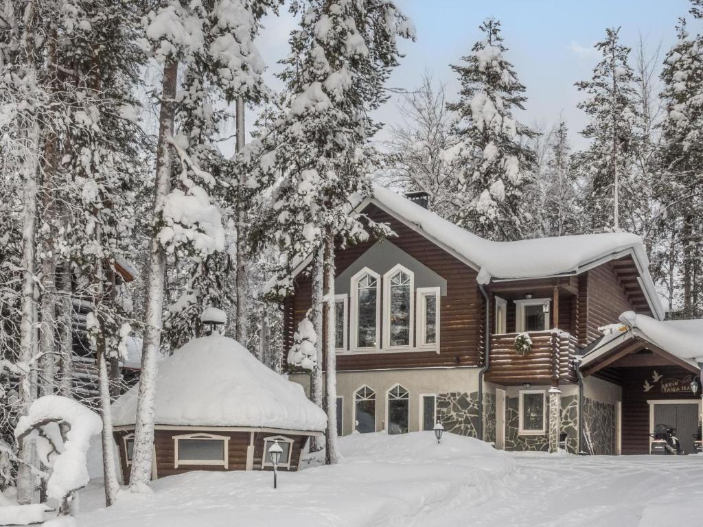 a house covered in snow in the woods at Holiday Home Levin taiga 18 a by Interhome in Sirkka