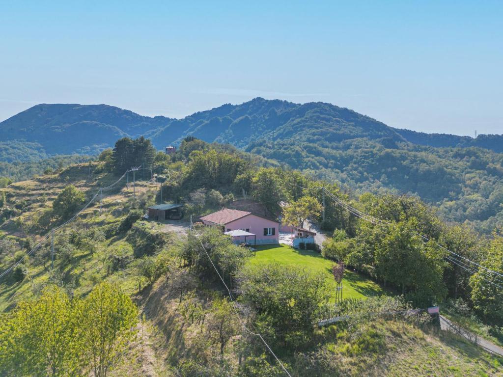 a house on a hill with mountains in the background at Holiday Home La Mela Musona by Interhome in Maissana