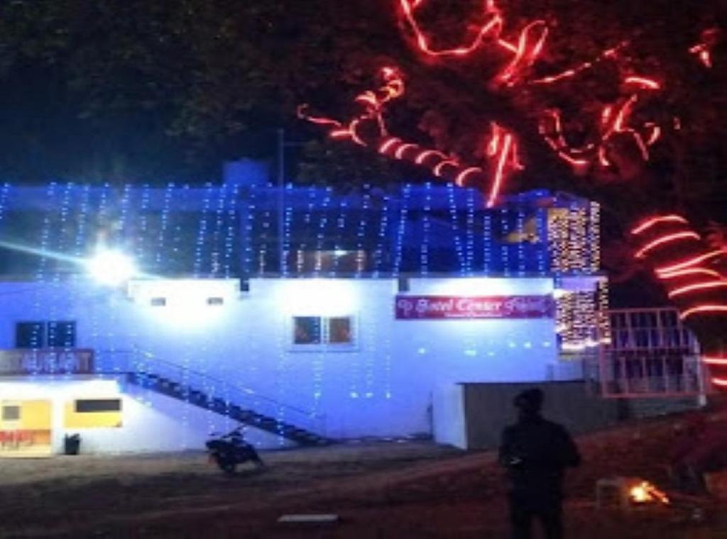 a man standing in front of a building with christmas lights at Hotel Center Point Kamleshwarpur 