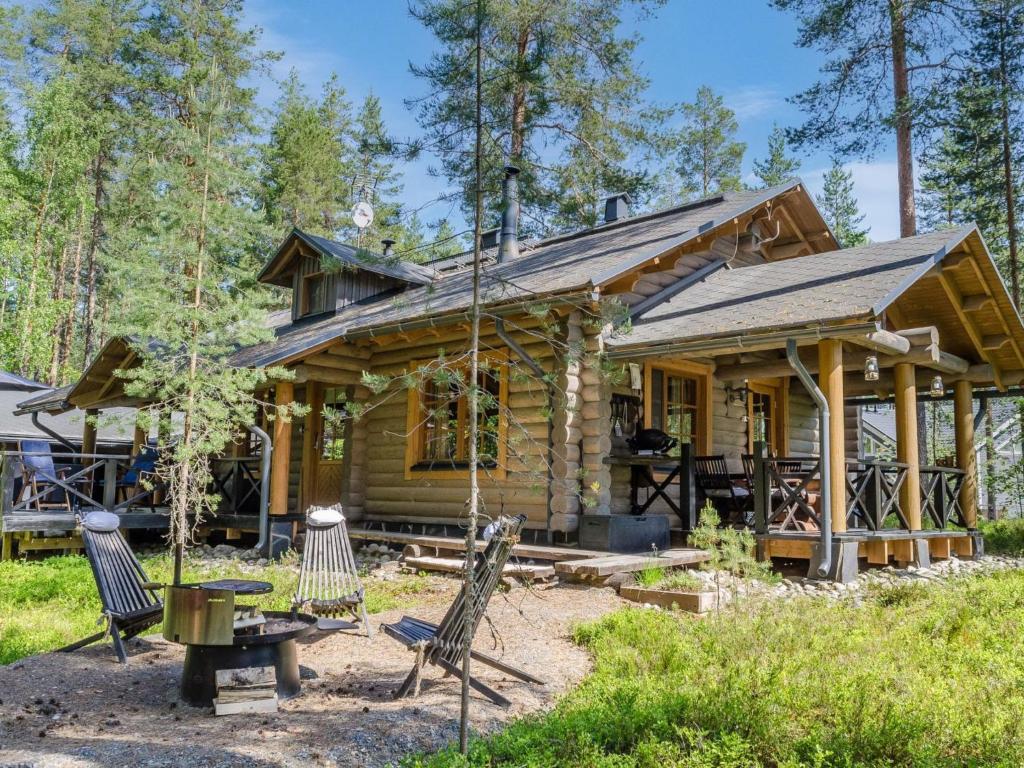 eine Blockhütte mit einem Picknicktisch und Stühlen davor in der Unterkunft Holiday Home Pyöröpirtti by Interhome in Hattusaari