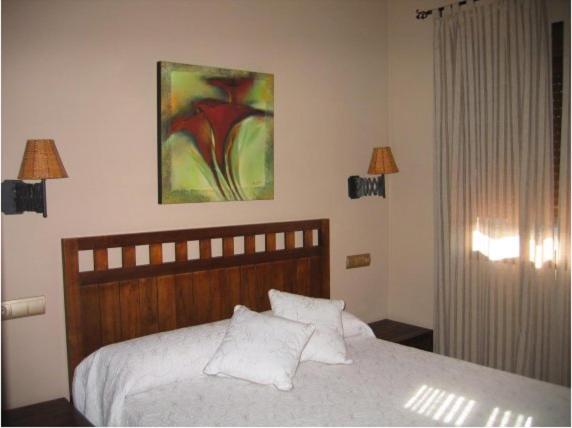 A bed or beds in a room at Hotel Rural Robles