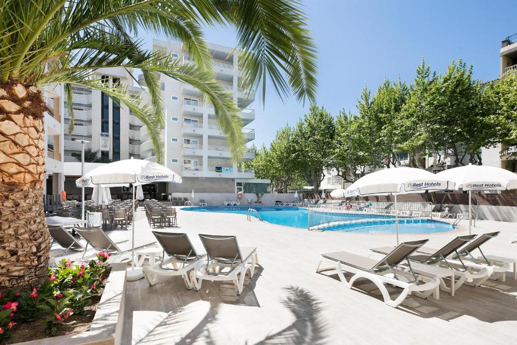 a pool with chaise lounge chairs and a palm tree at Hotel Best Da Vinci in Salou