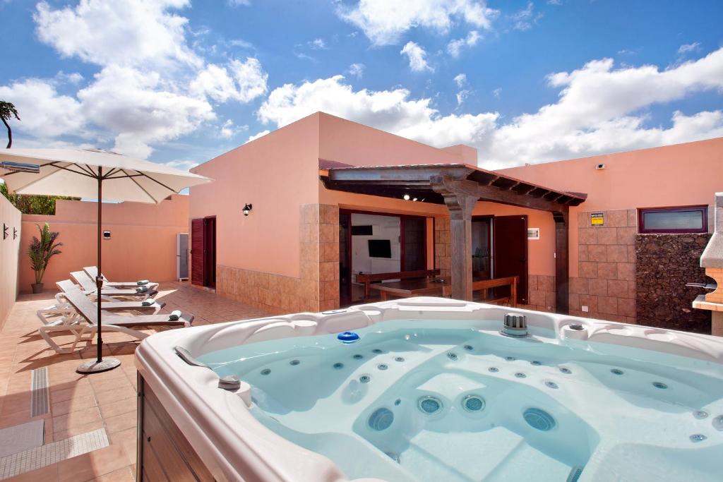 a hot tub on the patio of a house at Villa Malva in Corralejo