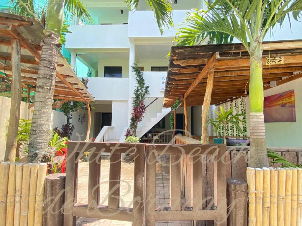 a wooden gate in front of a house with palm trees at WHITEBEACH DE BORACAY STATION 1 (EXTENSION) in Boracay