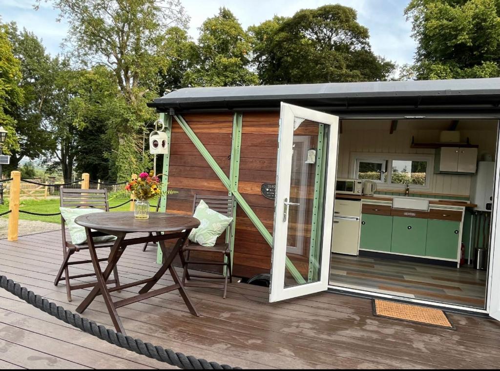 a tiny house with a table and a kitchen at Ted's Shed in Bishop Auckland