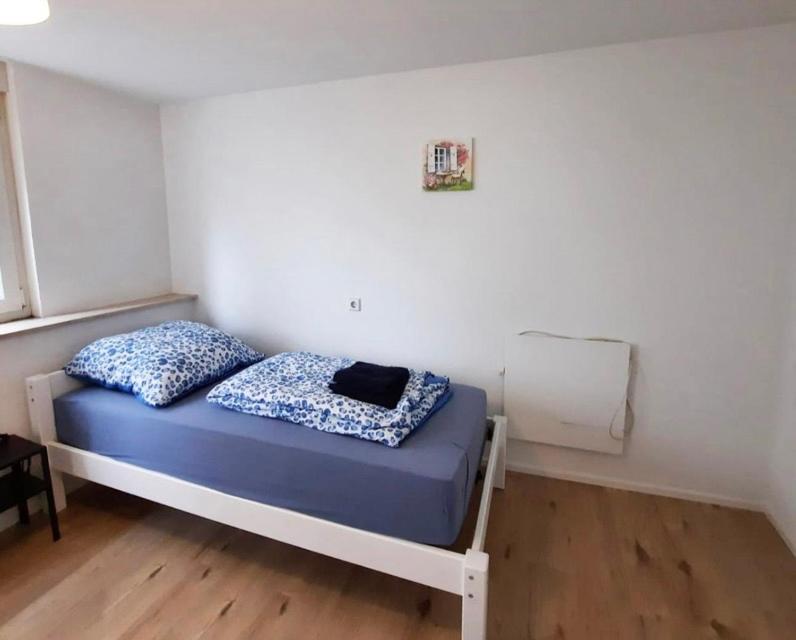 a small bedroom with a bed with blue sheets at home2stay worker house Nürtingen HS29 in Nürtingen