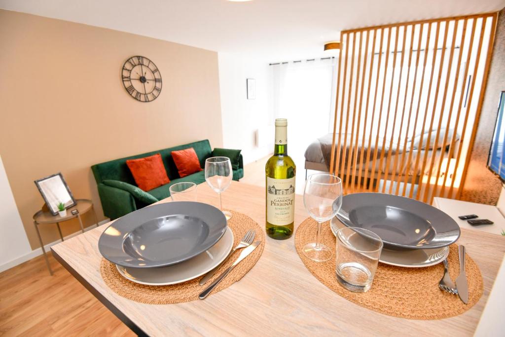 - une table avec une bouteille de vin et des verres dans l'établissement Studio MAGDA - Fibre et Tv - Calme et confortable, à Saint-Quentin