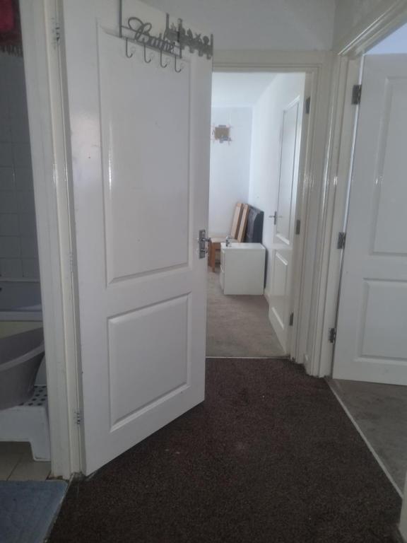 a hallway with a white door and a room at 1 Bet entire flat in Wellingborough