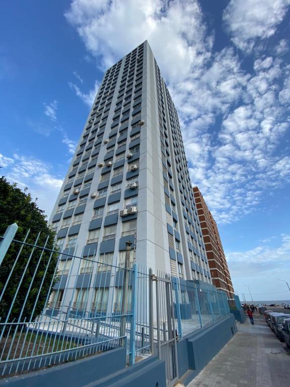 un edificio alto con una valla delante en Apartamento en Barrio Sur DOS HABITACIONES en Montevideo