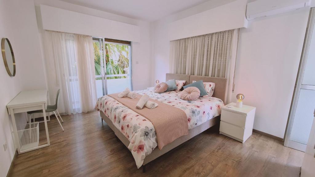 a bedroom with a bed and a desk and a window at STAY Vital Elegance in Limassol