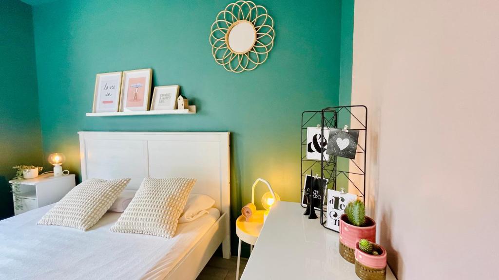 - une chambre avec un lit blanc et un mur vert dans l'établissement Au Grand Air - Maison de vacances Merlimont plage, à Merlimont