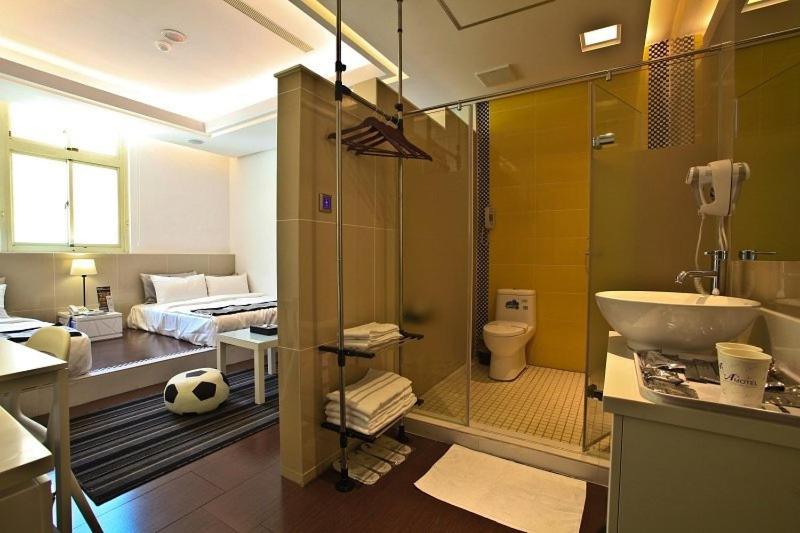 a bathroom with a sink and a toilet and a bed at King Motel王者 in Taoyuan