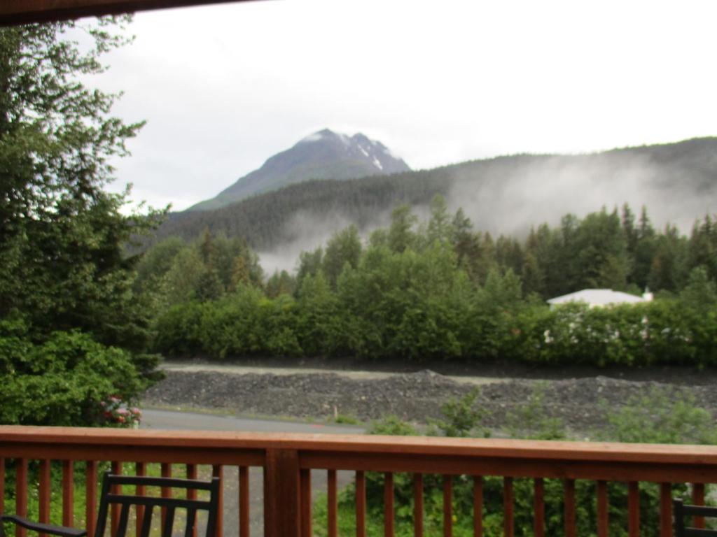 a view from the deck of a house with a mountain at SEWARD APARTMENT in Seward