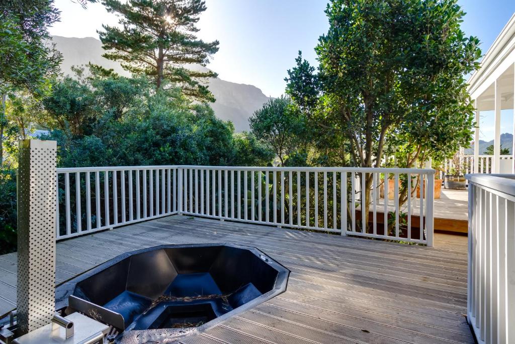 a patio with a fire pit on a deck at Exclusive Tree Cottage with hot tub - Power Back-up in Cape Town