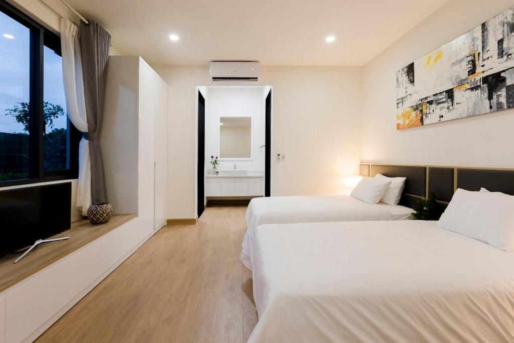 Cette chambre comprend 2 lits et une fenêtre. dans l'établissement SEA VILLA HỒ TRÀM, à Ho Tram