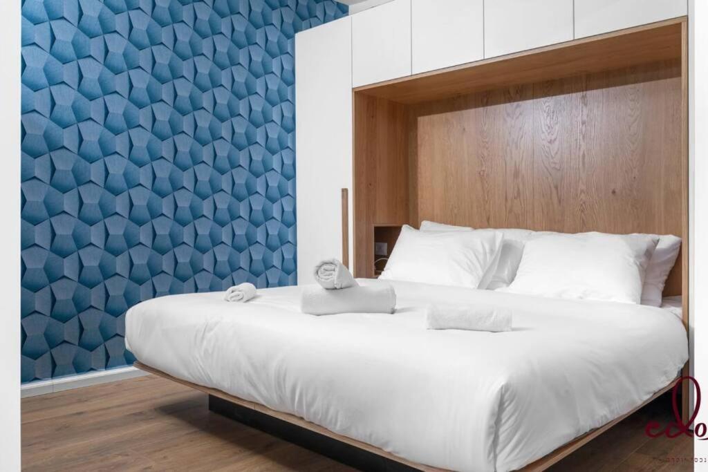 1 dormitorio con 1 cama grande y pared azul en דירה במתחם סי סייד 50 מטר מהים - By Edom, en Eilat