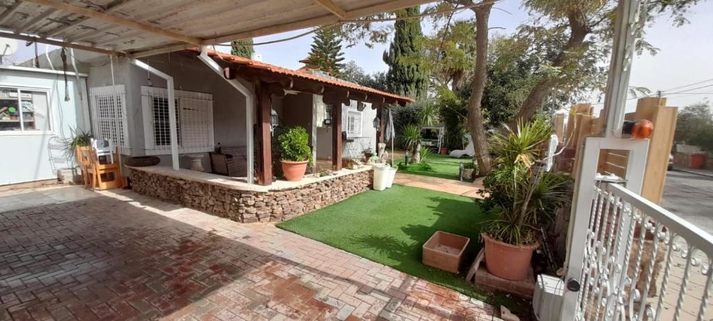 una casa con un patio con césped verde en arad rooms & apartments חדרי אירוח ערד, en Arad