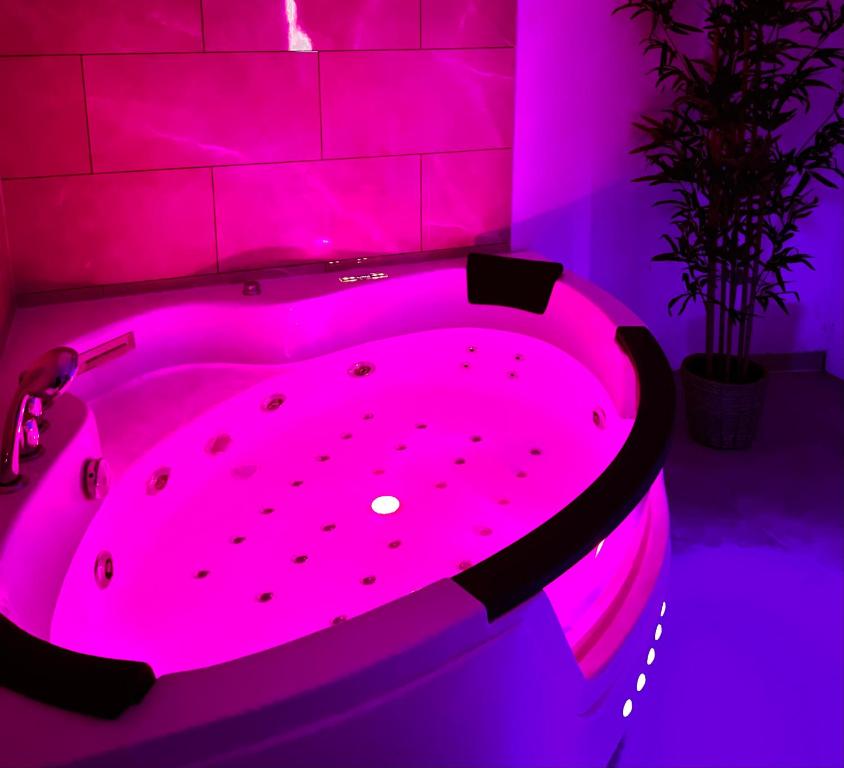 eine rosa Whirlpool-Badewanne in einem lila Zimmer in der Unterkunft Modern SPA - Cosy & Chic - JACCUZI in Brunoy