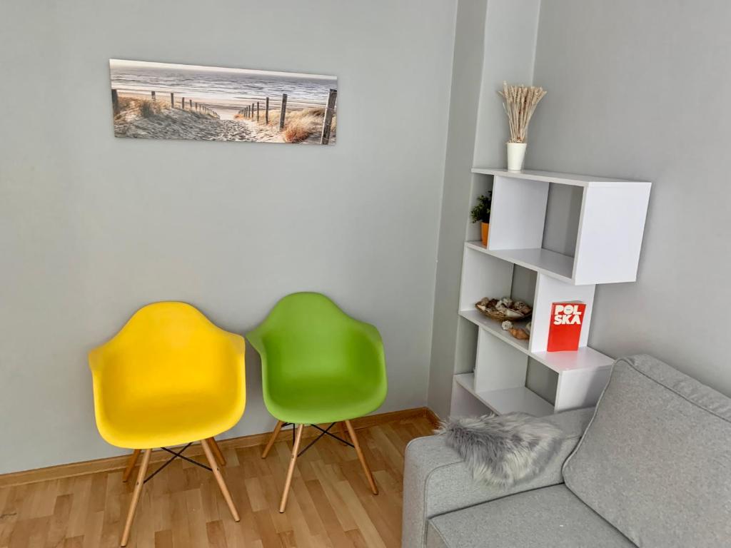 sala de estar con 2 sillas y sofá en Apartament Joanna parter blisko Onkologii, en Gliwice