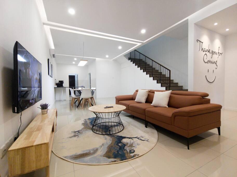uma sala de estar com um sofá e uma televisão em H+M Residence II [3km] to Setia City Convention em Klang